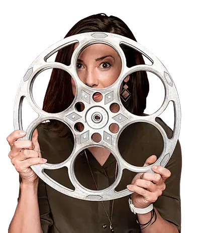 A woman holding up a silver film reel.