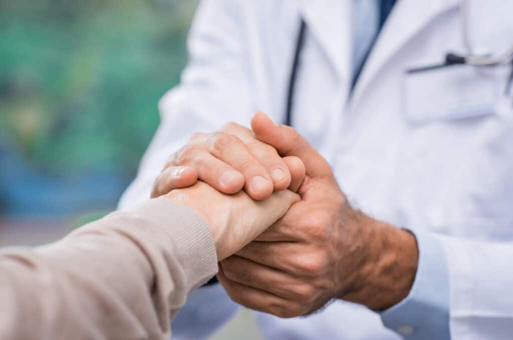 A doctor shaking hands with a patient.