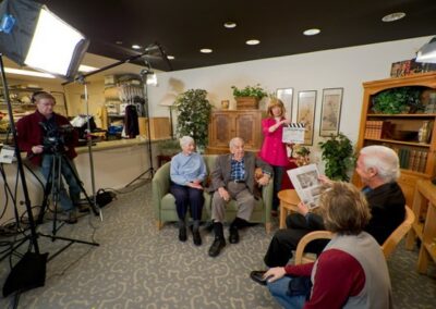 A group of people sitting in a living room with a camera.