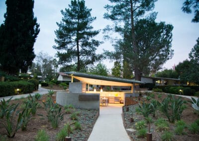 A modern house surrounded by trees and plants.