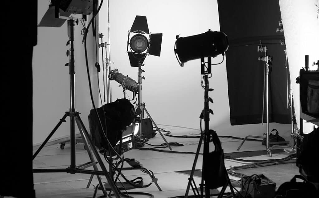 A black and white photo of a studio with lighting equipment.
