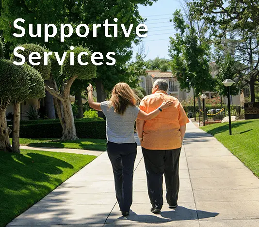 A couple walking down a sidewalk with the words supportive services.