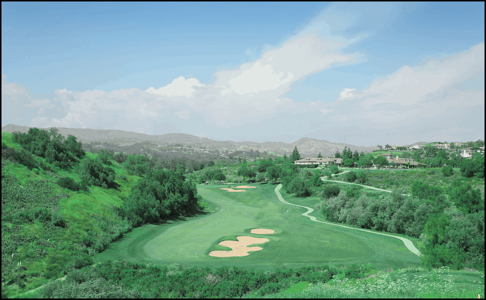 A green golf course in a mountainous area.